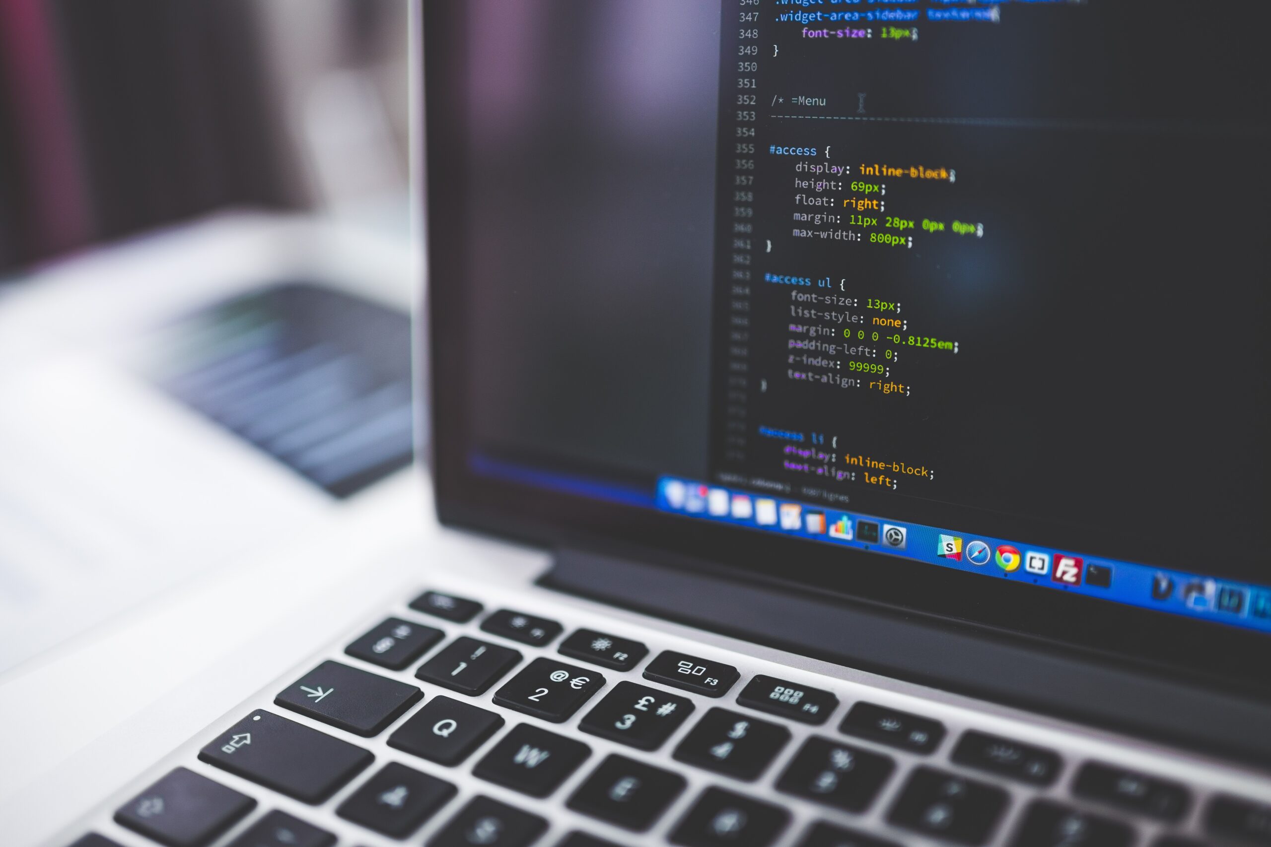 Laptop showing programming code, used as a generic technology-sector illustration